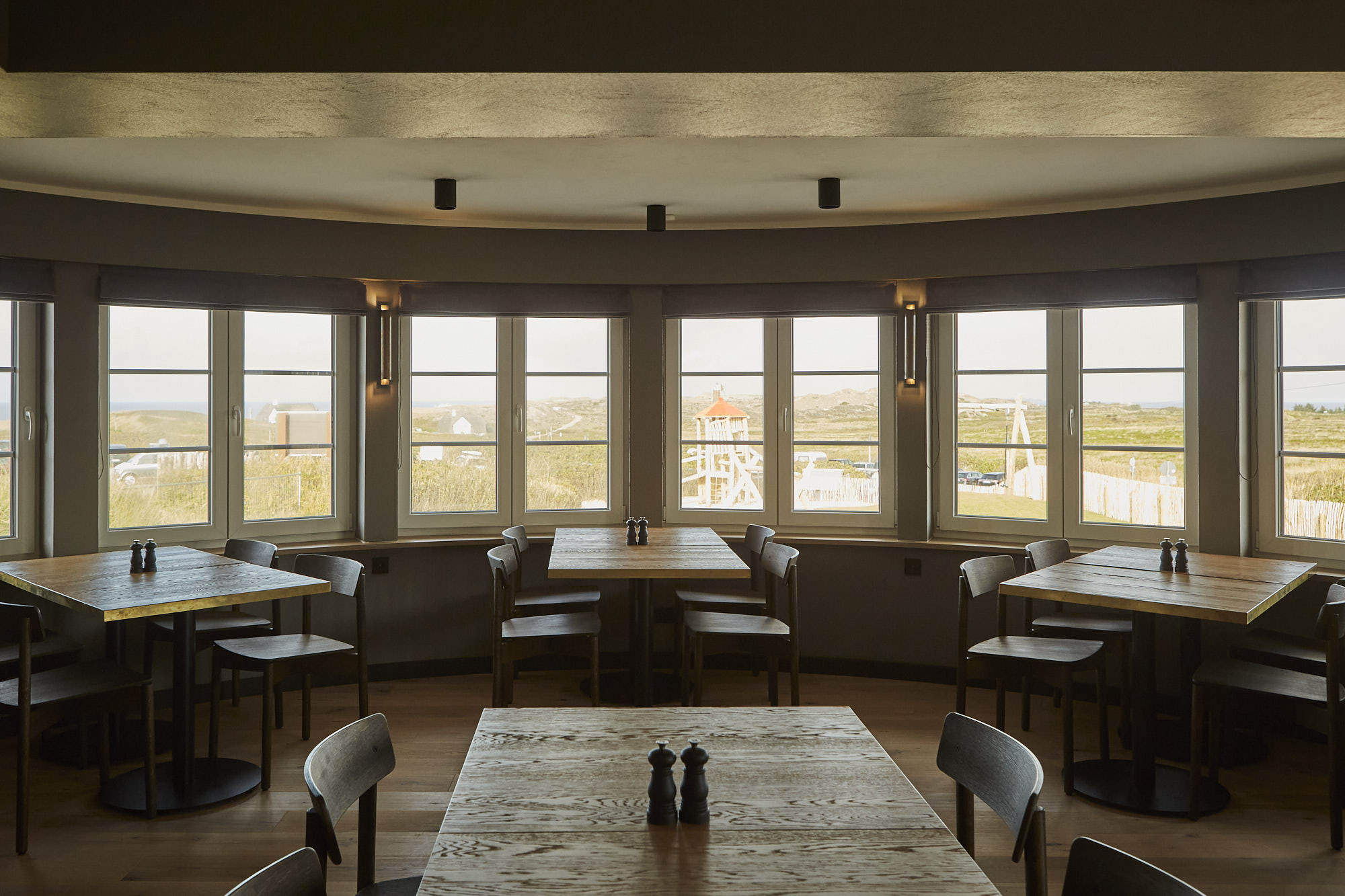 Dining room with oak tables looking out over the dunes