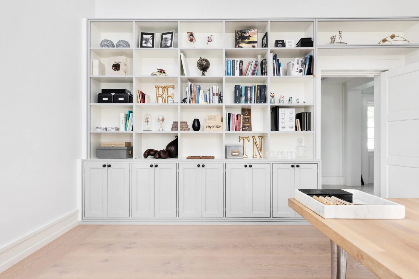 White built-in bookcase above a pale oak floor